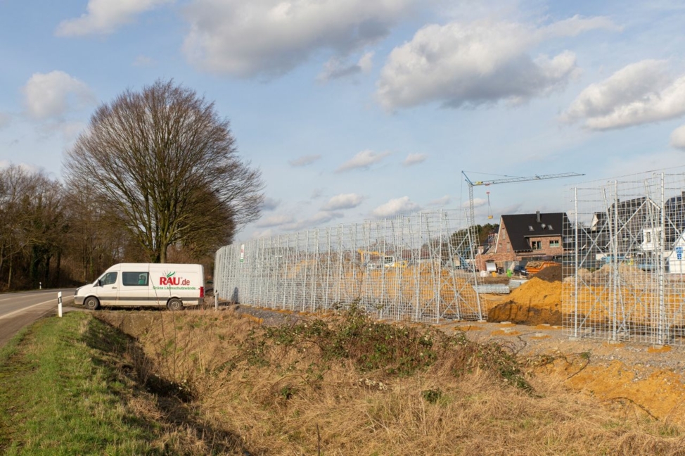 Scaffolding of a noise barrier at a construction site next to a residential area.
