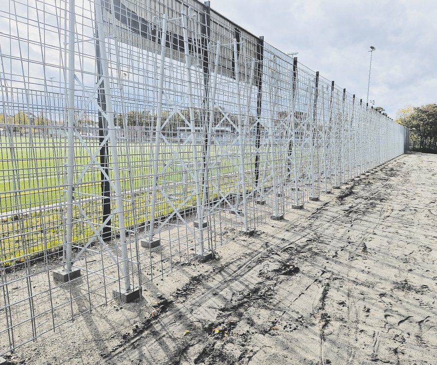 Scaffolding for a noise barrier at a sports field.